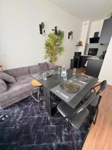 a living room with a table and a couch at Chill & Play in Casteljaloux