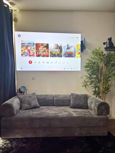 a projection screen hanging on a wall with a couch at Chill & Play in Casteljaloux