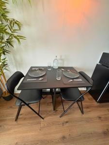 a black table with chairs and glasses on it at Chill & Play in Casteljaloux +14 photos