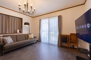 a living room with a couch and a flat screen tv at N-Stream Old Karuizawa West in Karuizawa