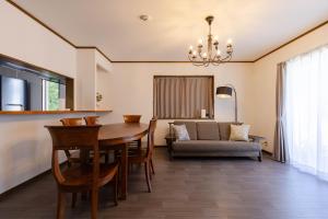 a dining room with a table and a couch at N-Stream Old Karuizawa West in Karuizawa