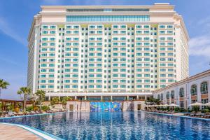 a large building with a large swimming pool in front of it at Sokha Phnom Penh Hotel in Phnom Penh