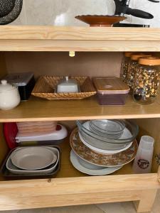 a wooden shelf with plates and other dishes on it at Najam café in Saïdia