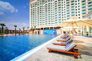a row of lounge chairs next to a pool at a hotel at Sokha Phnom Penh Hotel in Phnom Penh