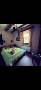 a bedroom with a green bed and a window at Etno kuća Todorović in Smederevo