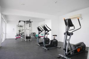 a gym with several exercise bikes and treadmills at Beachfront Bliss Ocean Views & Sunset Views 