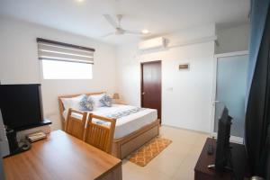 a small room with a bed and a television at Beachfront Bliss Ocean Views & Sunset Views 