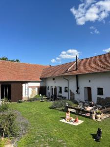 a group of people sitting in the yard of a house at Prostě statek in Skalka