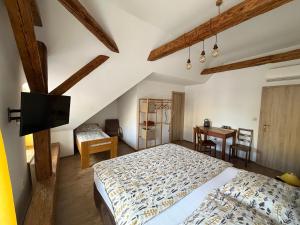 a bedroom with a bed and a desk and a table at Penzion Ambrozie in Seč