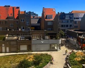 a group of people walking in a city with buildings at Logies Zen aan Zee in Ostend