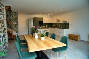 a kitchen and dining room with a wooden table and chairs at Maison Serrioux in Cholonge