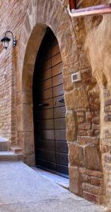 eine große Holztür in einem Backsteingebäude in der Unterkunft Il Nido delle Marche in Sarnano
