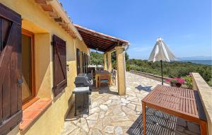 a patio with a grill and a table and an umbrella at Villa Pisicne in Mons