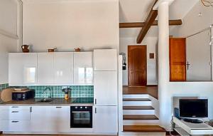 a kitchen with white cabinets and a staircase in it at Villa Pisicne in Mons
