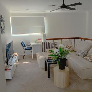 a living room with a couch and a table at "Casa Serena" - Spacious Entire Holiday Home in Caboolture