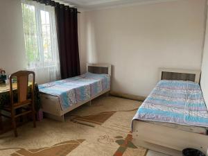 a room with two beds and a chair in it at Camp&CO in Naryn