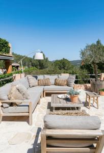a patio with couches and tables on a patio at Casa Naya Ibiza in Sant Llorenç de Balafia
