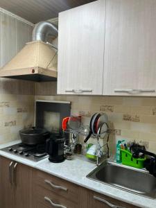 a kitchen counter with a sink and a stove at Camp&CO in Naryn