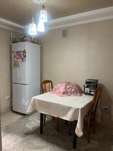 a kitchen with a table and a white refrigerator at Camp&CO in Naryn