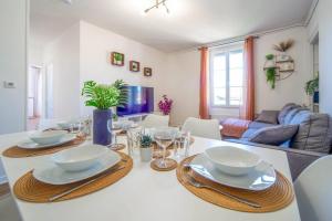 a dining room with a table with plates and bowls at Le Chagnotin in Chagny +9 photos