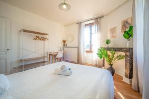 a bedroom with a white bed and a desk at Le Chagnotin in Chagny