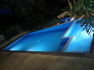 a blue swimming pool at night with the number seven at Sunny Hill Villa in Mirissa