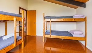 a room with two bunk beds and a hallway at Ossies Motels and Chalets in Ohakune
