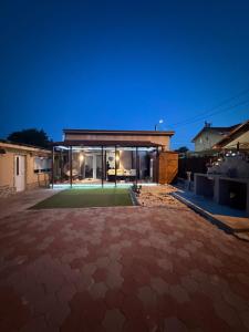 a house with a large courtyard at night at Casa Dutu in Tuzla
