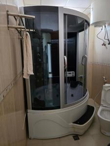 a bathroom with a shower with a toilet in it at Yiganda Hotel, Ethiopia in Bahir Dar