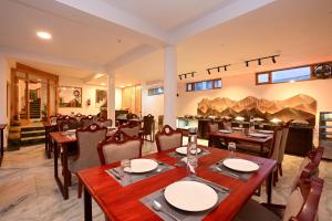 a dining room with wooden tables and chairs at Hotel Karakoram in Leh