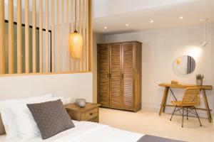 a bedroom with a bed and a desk with a chair at Calmare suites in Rethymno