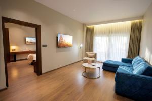 a living room with a blue couch and a bed at Surya Grand Hotel in Kalpetta