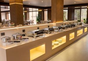 a buffet line in a restaurant with dishes on display at Surya Grand Hotel in Kalpetta