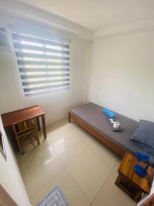 a room with a bed and a table and a window at Raje Residence El Nido in El Nido
