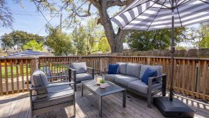 a patio with a couch and two chairs and an umbrella at Hideaway on Oak by AvantStay in Paso Robles