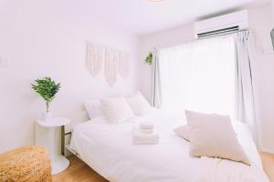 a white bedroom with a white bed and a window at Chic 1 Bedroom Space Near Nakasu in Fukuoka