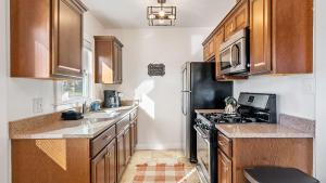 a kitchen with wooden cabinets and a black stove top oven at Paso on Oak by AvantStay in Paso Robles