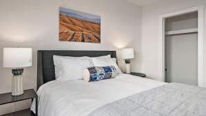 a bedroom with a large white bed with two lamps at Paso on Oak by AvantStay in Paso Robles