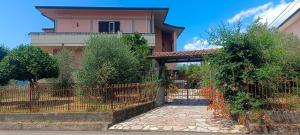 a fence in front of a house with a gate at Affittacamere Casa Sermide in Caniparola di Fosdinovo