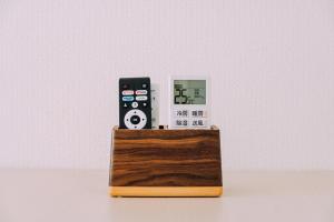 two remote controls sitting on top of a wooden box at Chic 1 Bedroom Space Near Nakasu in Fukuoka