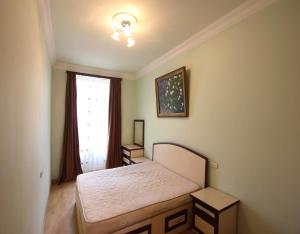 a small bedroom with a bed and a window at Apartment by Opera in Yerevan