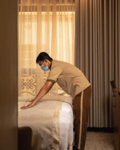 a man bending over a bed with a mask on at Bosphorus Hotel Grand Safi in Medina +8 photos