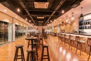 un restaurant avec des tabourets en bois et un bar dans l'établissement Jie Jie Beach by Jetwing, à Wadduwa