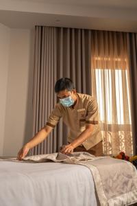 a man is making a bed with a mask on at Bosphorus Hotel Grand Safi in Medina