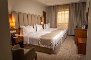 a hotel room with a large bed and a chair at Bosphorus Hotel Grand Safi in Medina