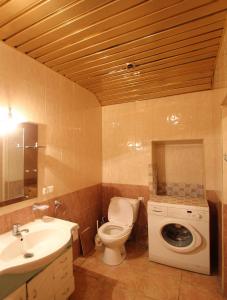 a bathroom with a toilet and a sink and a washing machine at Apartment by Opera in Yerevan