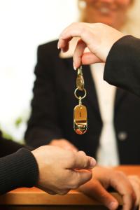 a person in a suit holding a key at Residenz Royal in Gmünd