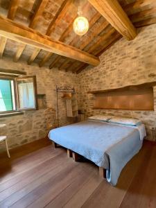 a bedroom with a large bed in a brick wall at B&B Mulini Venturi in Saludecio