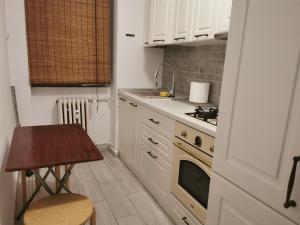 a small kitchen with a stove and a table at Apartament Clau Centru Vechi in Constanţa