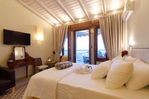 ein Schlafzimmer mit einem großen Bett und einem großen Fenster in der Unterkunft Smaragdi Boutique Hotel in Rethymno